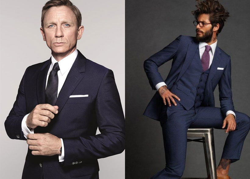Two men in cocktail attire suits. One, Daniel Craig, has a black tie and white pocket square. The other wears a red tie with white pocket square. 