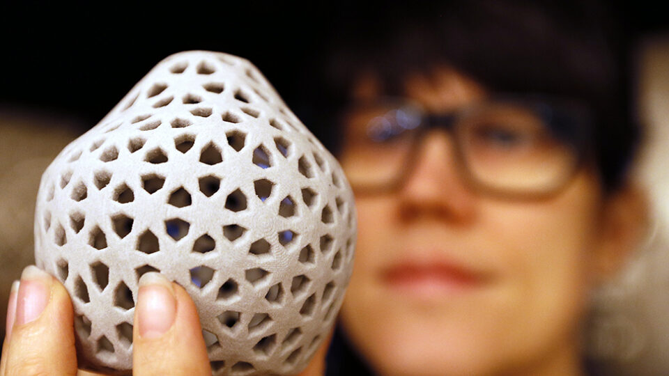 Designer Penelope Kupfer displays a biscuit made from insect flour at the Wellcome Collection in London, Tuesday, April 23, 2013. The exhibition of Illuminated room-high insect traps, dramatic Iight projections of creepy crawlies and 3D printing of food made from bugs is a new installation called "Insects au Gratin" which explores the benefits of eating bugs, as part of a new season called Who's the Pest? organised with Pestival - the cultural organisation dedicated to our relationship with insects and the natural world. (AP Photo/Kirsty Wigglesworth)