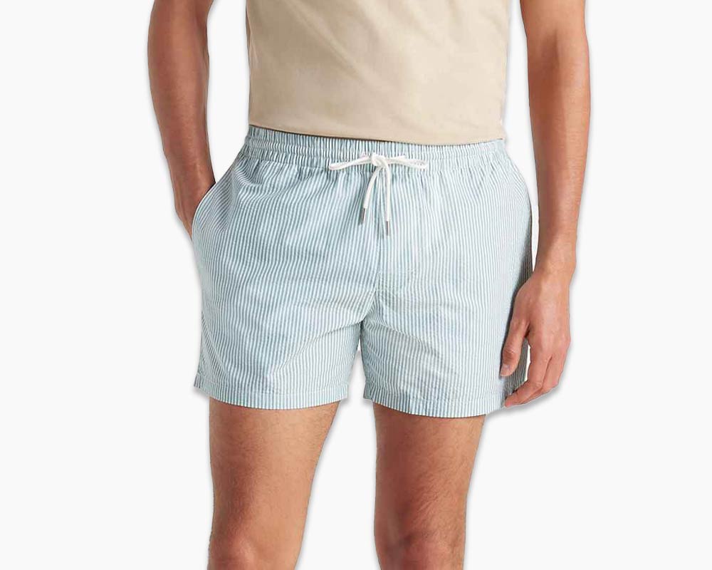 Man wearing Club Monaco swim shorts in light blue