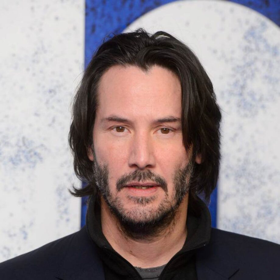 Keanu Reeves with medium-length curtains hairstyle. 