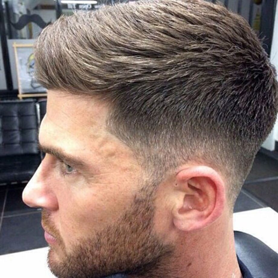 Man with brown Ivy League hairstyle with low taper fade.
