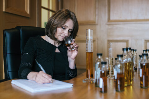 A woman nosing whisky.