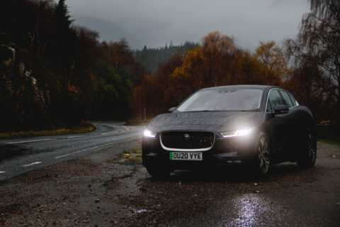 A Jaguar I-PACE electric car by the side of the road in Glencoe, Scotland.