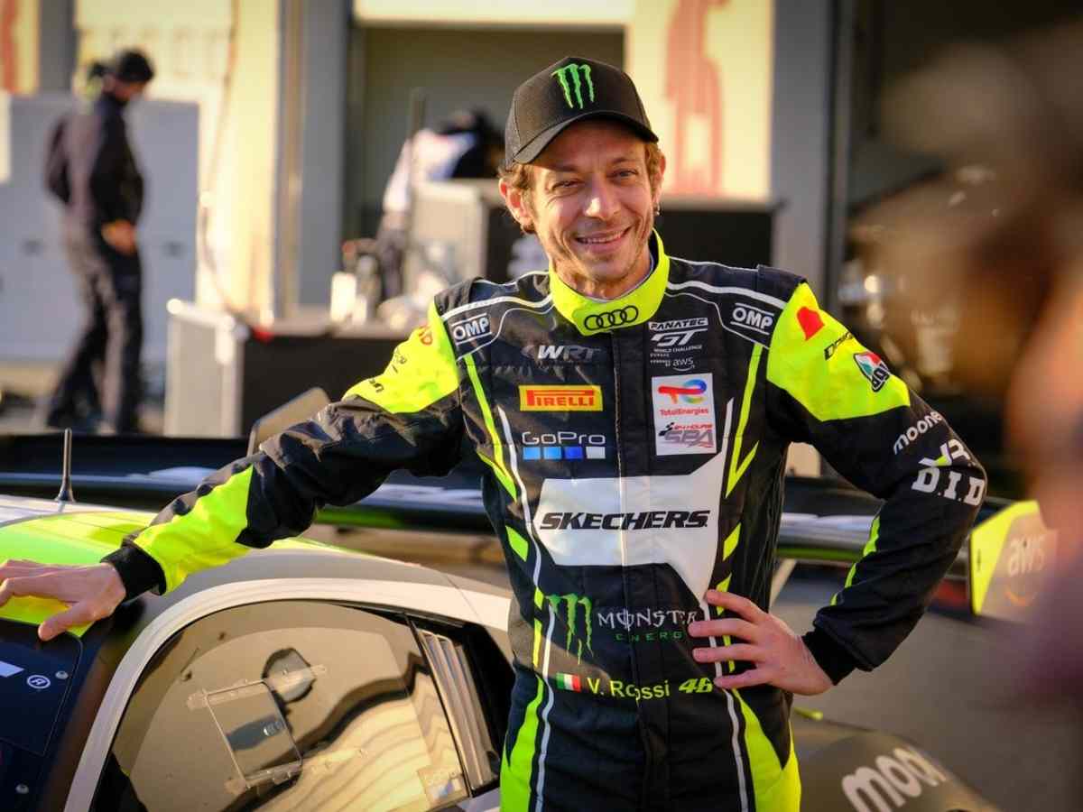Valentino Rossi leans against a car at the 2023 Dubai 24 Hour.