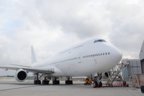 An unpainted Boeing 747 plane at an airgate.