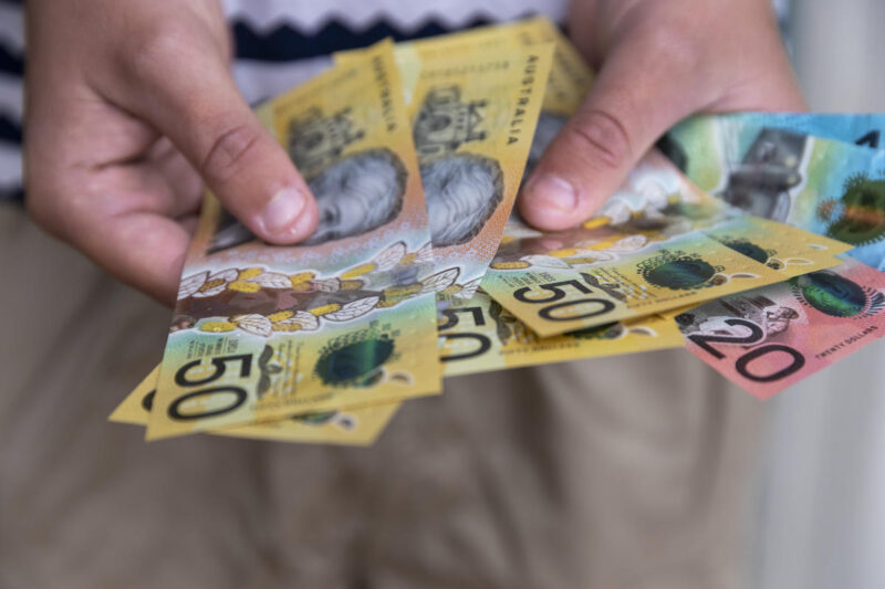 A person flipping through Australian $50 notes.