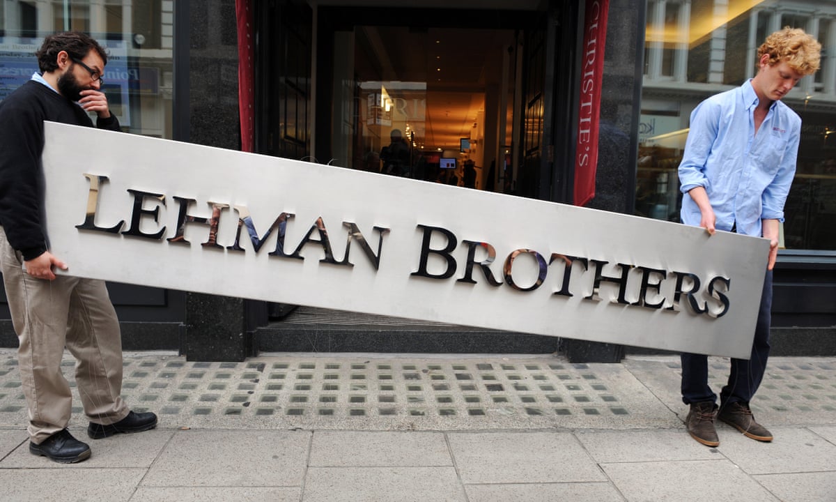 Two men carry a Lehman Brothers sign.