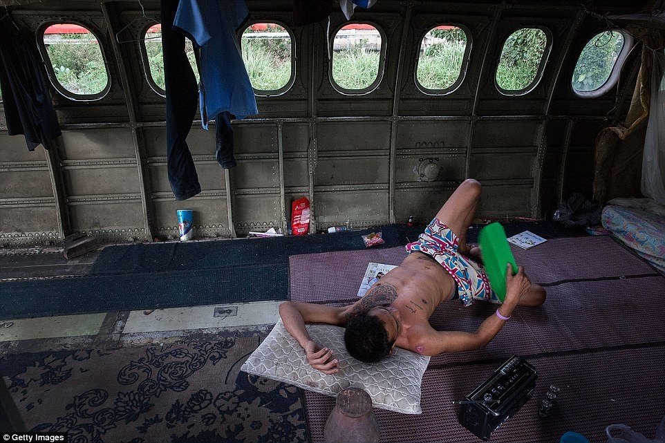 A man sleeping in an abandoned plane.