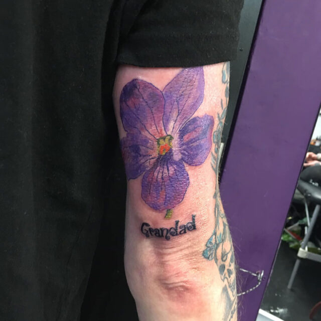 Tatuagem de flor na parte de trás do braço
