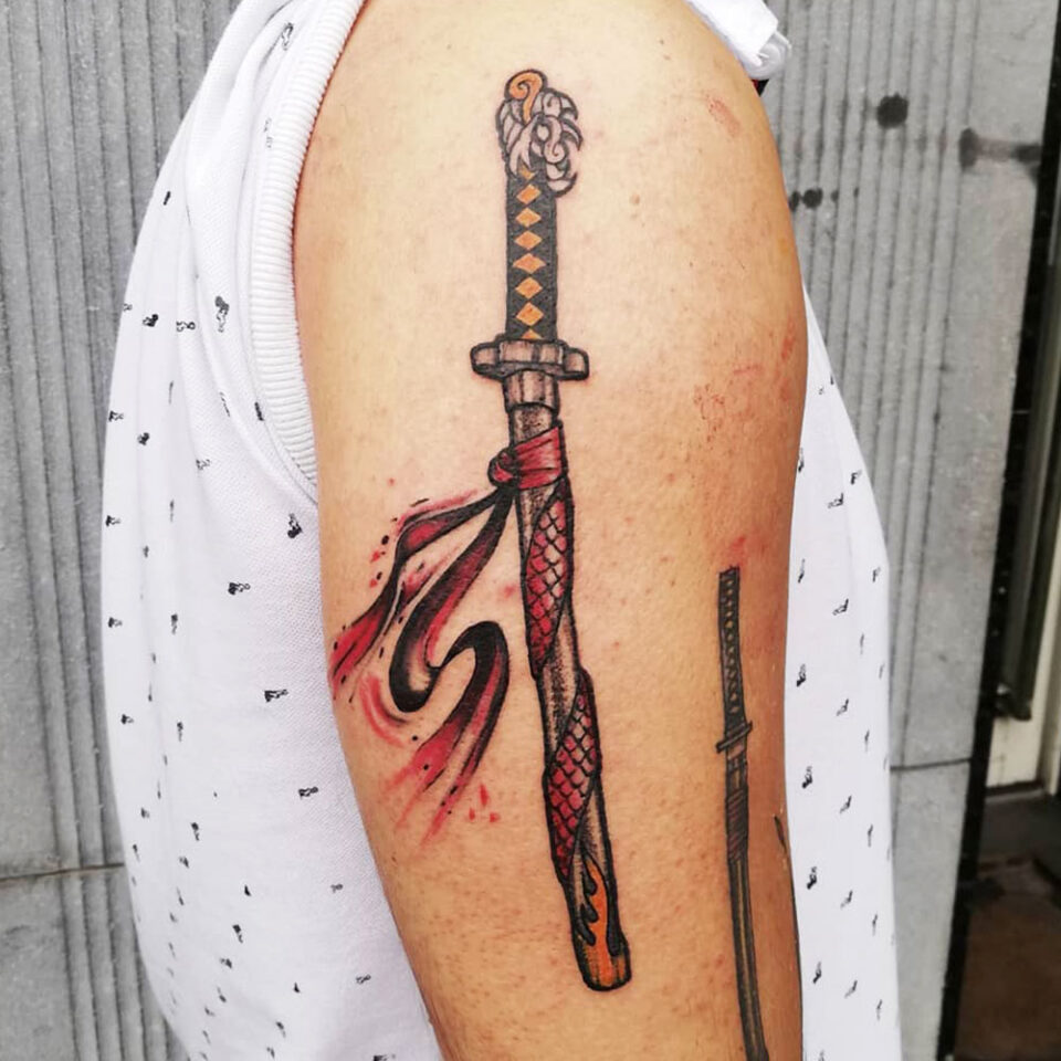 Sword with dragon head tilt tattoo Source @gabrielvirosus via Instagram