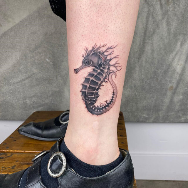 Fonte de tatuagem de cavalo-marinho aquático no tornozelo @sash_inks via Instagram