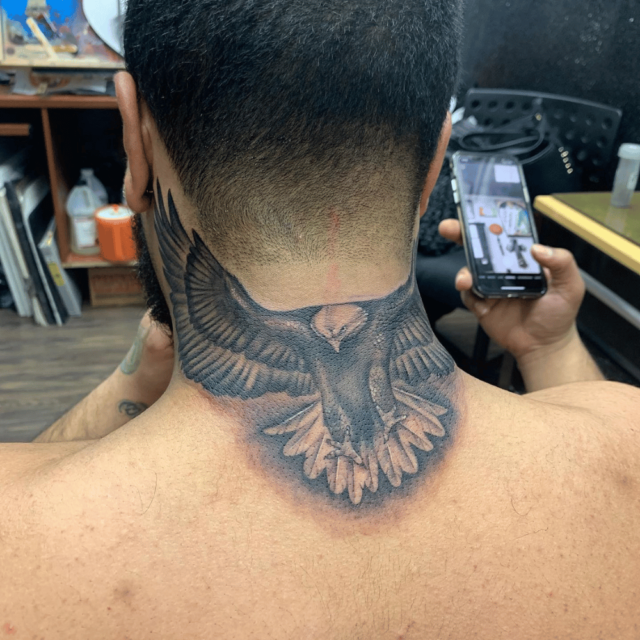 Fonte de tatuagem de envergadura de águia em vôo no pescoço @shinos_ink via Instagram