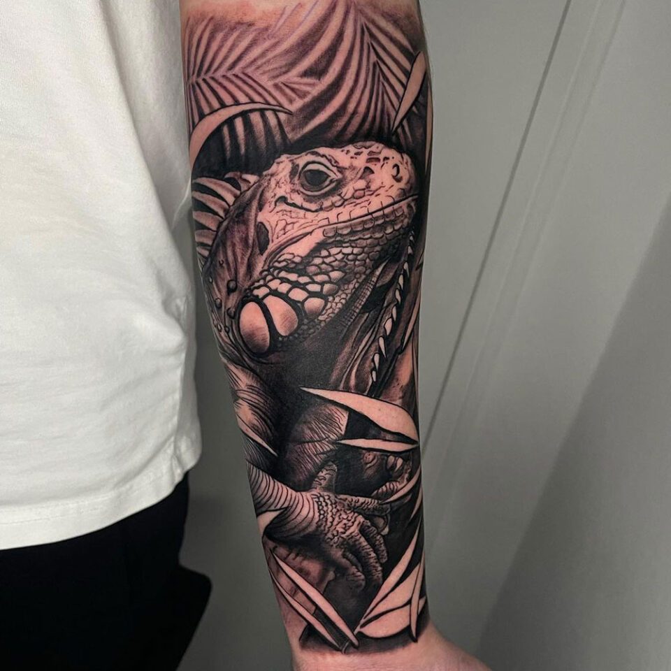 Iguana em um galho Fonte de tatuagem de animal de estimação @pawel.inkdistrict via Instagram