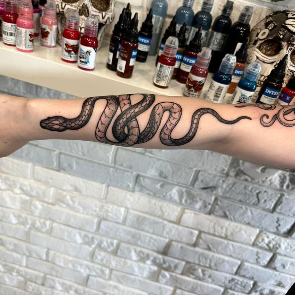 Cobra enrolando o antebraço Fonte de tatuagem de animal de estimação @goat.tattoo_warszawa via Instagram