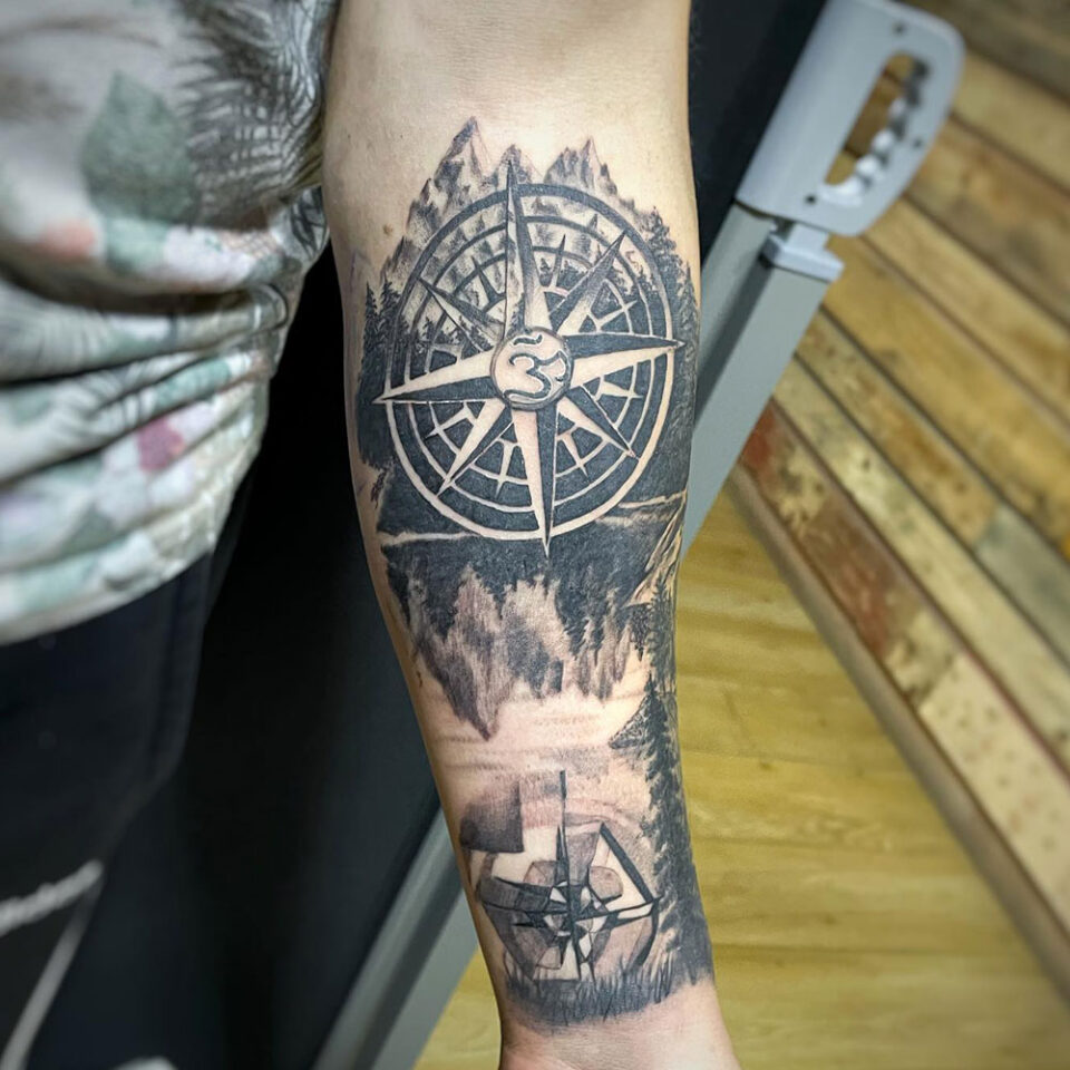 compass with mountain landscape tattoo Source @emmarainetattoo via Instagram