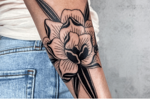 Fonte de tatuagem de flor de amarílis @unbound.ink via Instagram