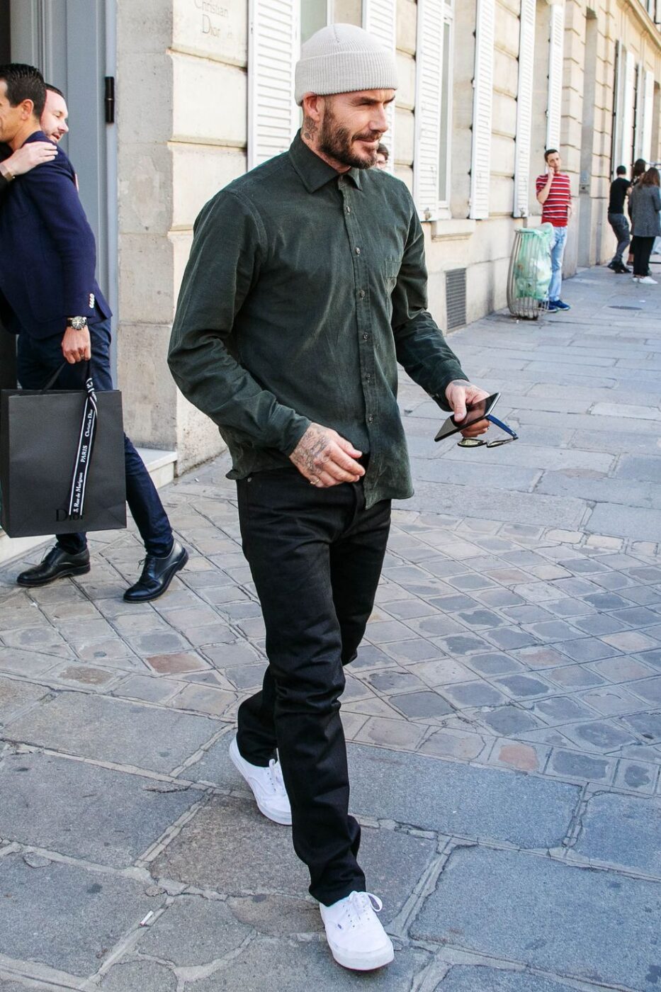 David Beckham wearing black jeans with white sneakers and a green shirt. 