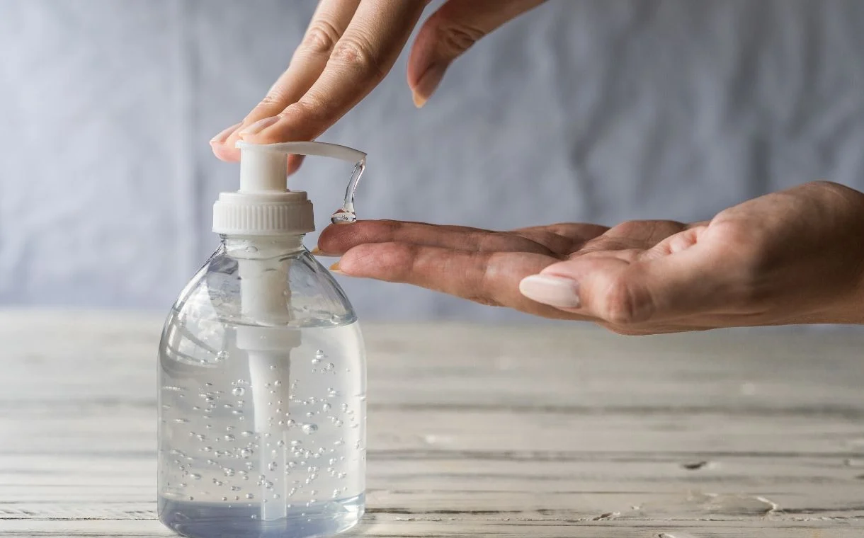 A woman using hand sanitiser. 